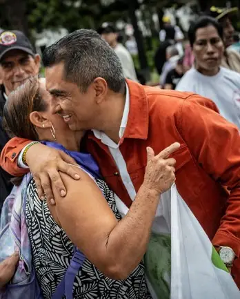 Víctor Armando abraza a una señora en un encuentro con la comunidad